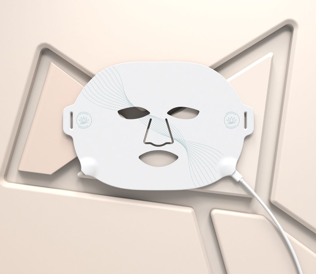 White CAIRSKIN RE-Light silicone mask resting on a beige sculptural background