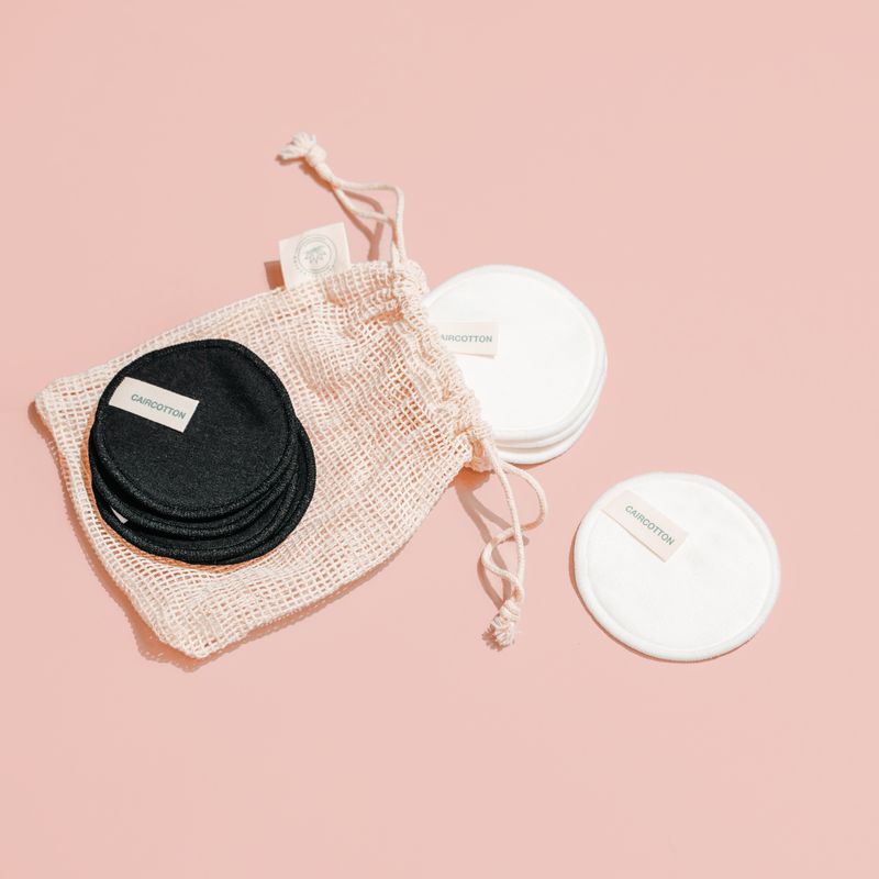 Black and white CAIRCOTTON reusable cotton pads with a mesh wash bag