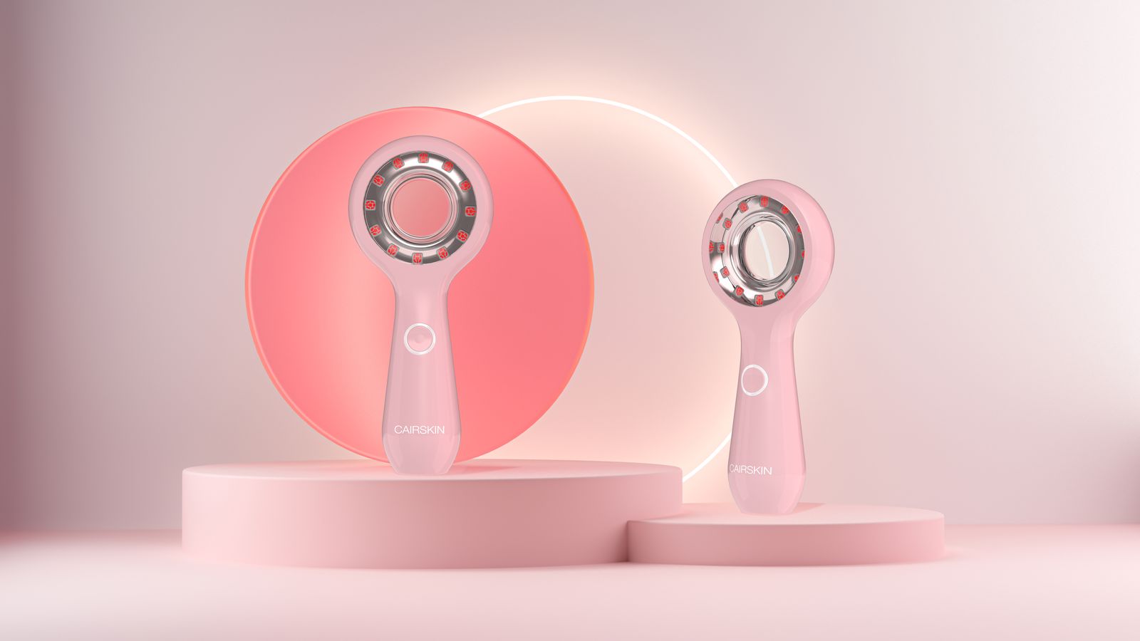 Two pink CAIRSKIN Collagen Booster LED devices on pink podiums in front of a glowing ring