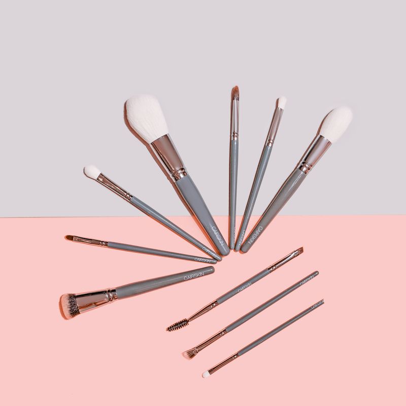 Slate grey CAIRSKIN brushes with silver ferrules on grey and pink
