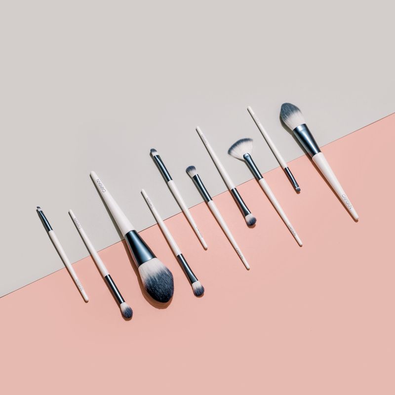 White CAIRSKIN brushes with graphite ferrules in a diagonal row